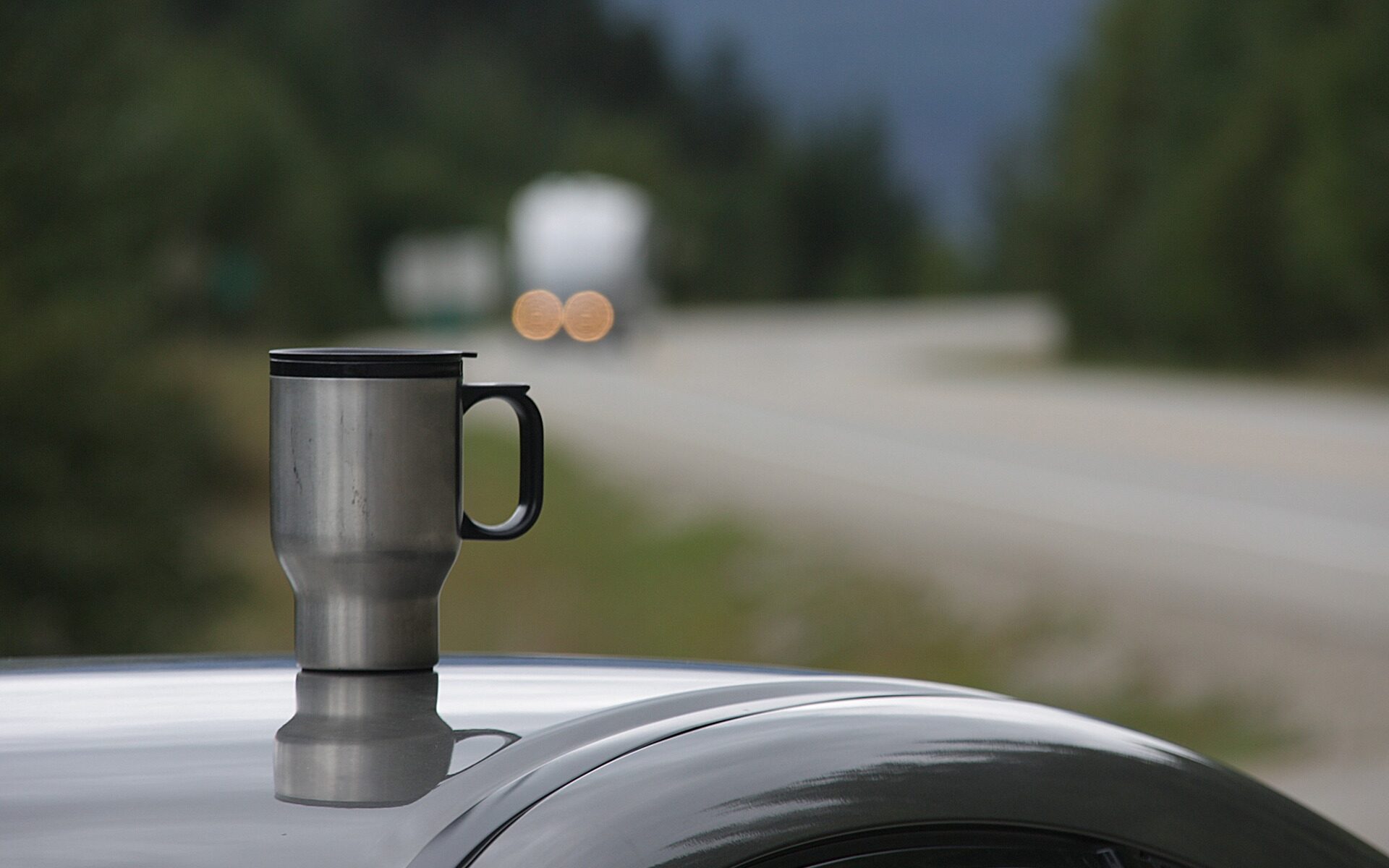 a travel mug siting on top of a car